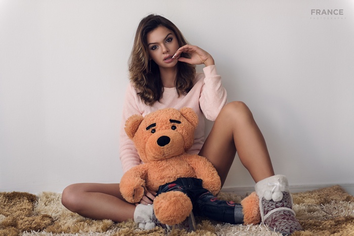 Woman with teddy bear on rug