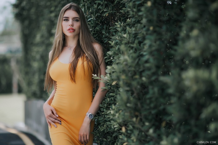 Woman with long hair wearing a yellow dress outdoors
