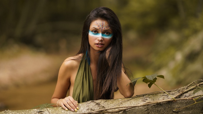 Woman with face paint in forest