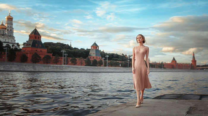 Woman walking by the Moscow Kremlin on the river