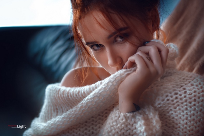 Woman with red hair wearing a white sweater