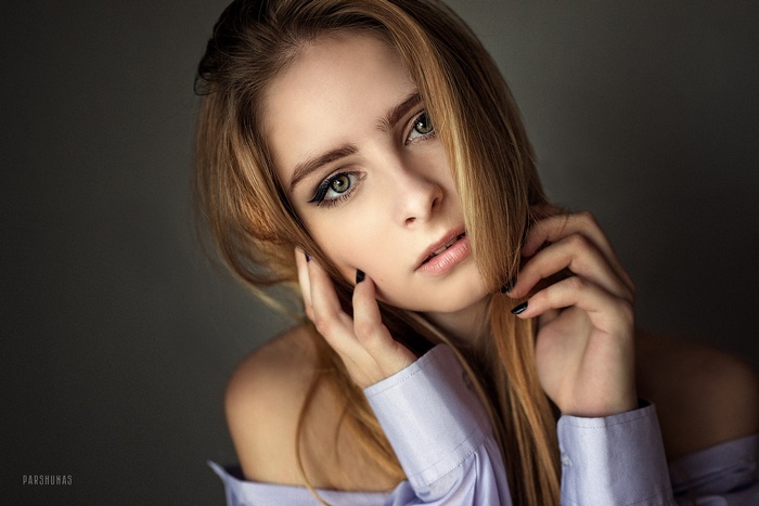 Woman with blonde hair and green eyes wearing a shirt