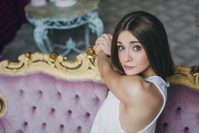 Woman with blue eyes on a pink couch