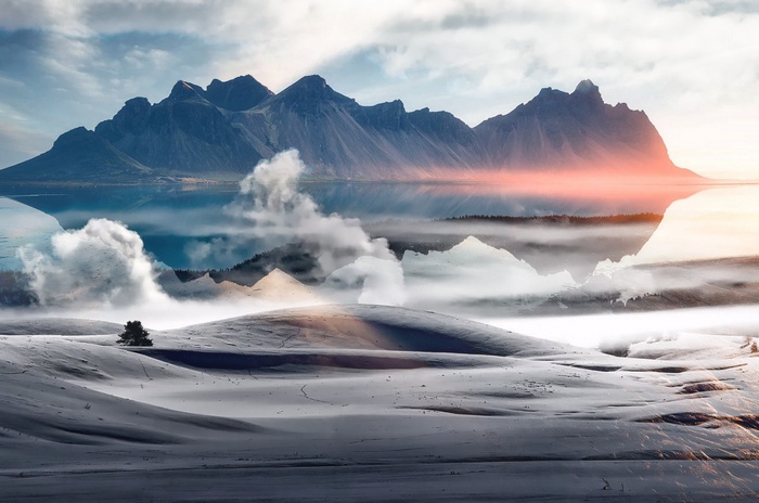 Snowy landscape with mountains and reflection