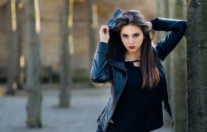 Woman with sunglasses and leather jacket outdoors