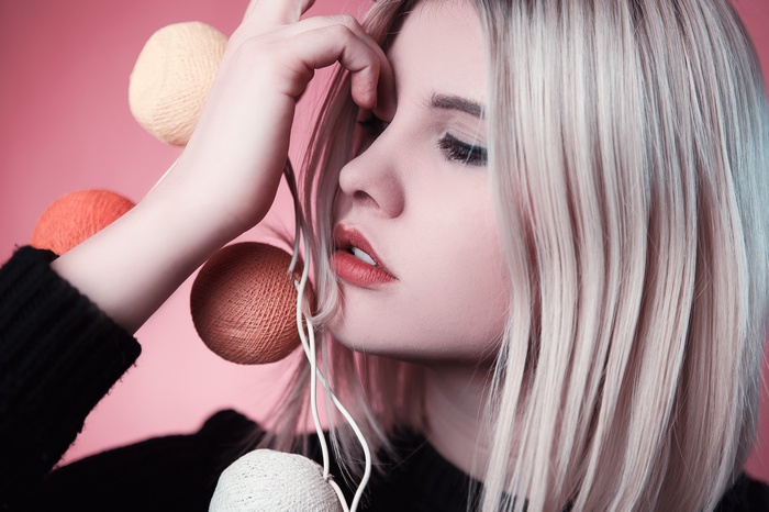 Woman with blonde hair and makeup holding decorative balls