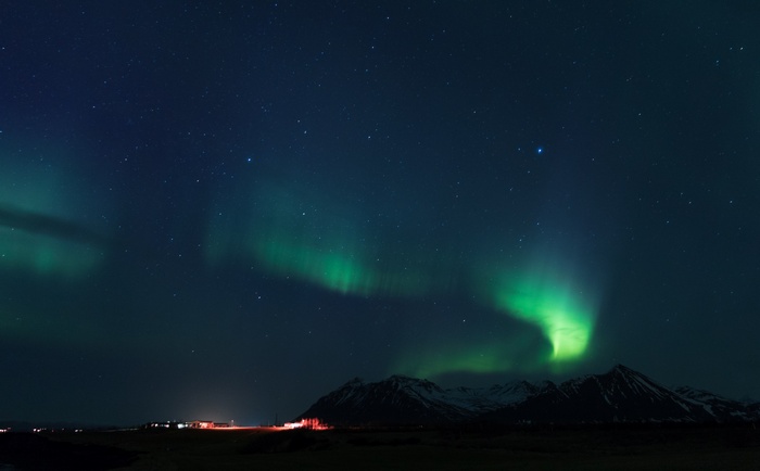 Aurora Borealis over mountains and town