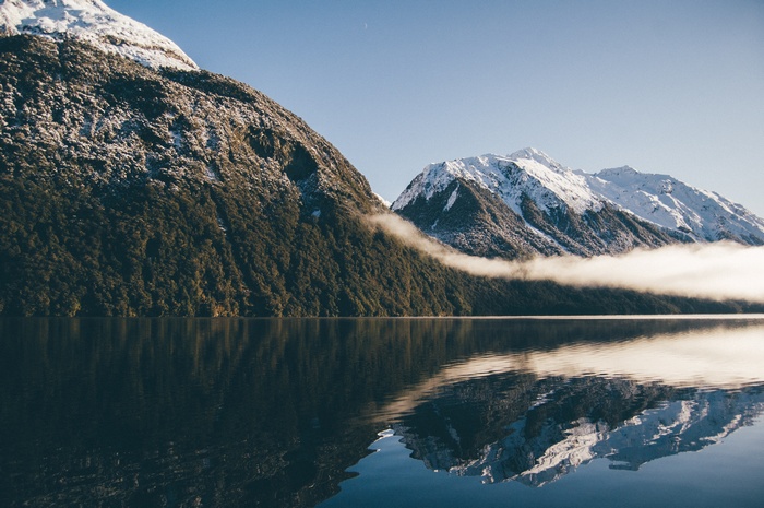 Snow-capped mountains reflected in a calm lake