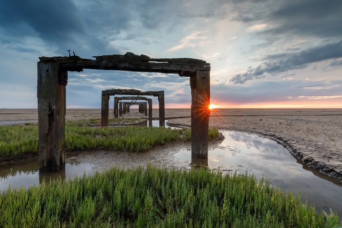 Wooden structures on a beach at sunset