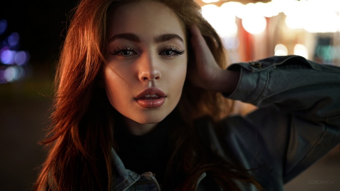 Woman with auburn hair in a denim jacket