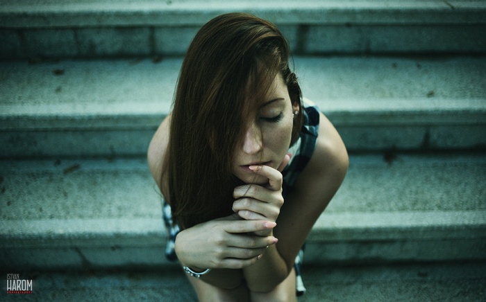 Model with auburn hair sitting on stairs