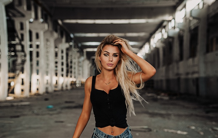 Blonde woman with pierced navel in abandoned building