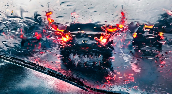 Traffic lights seen through a rain-streaked windshield
