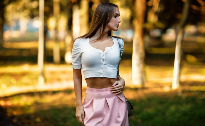 Woman in white sweater and pink skirt outdoors