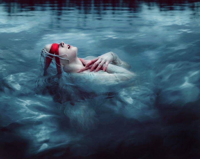 Woman with red blindfold in water