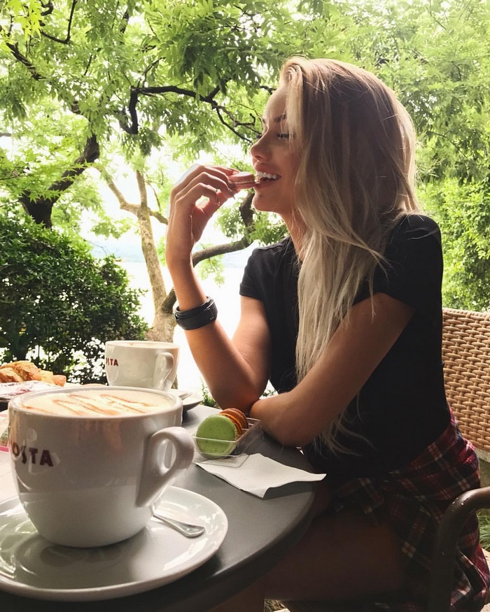 Woman eating macaroons at a cafe