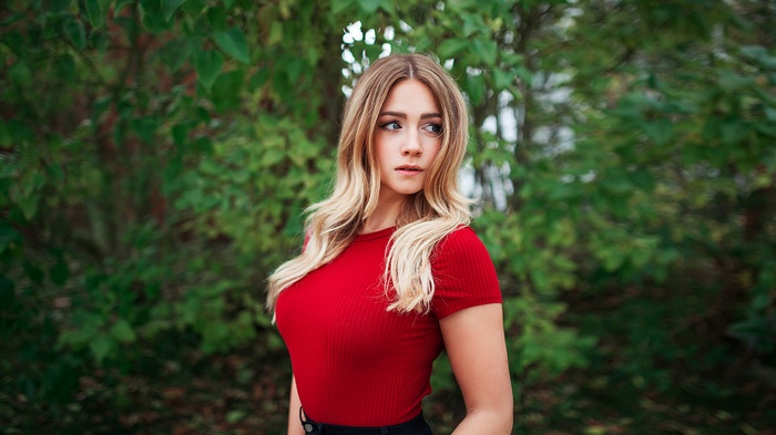 Woman with blonde hair in a red shirt outdoors