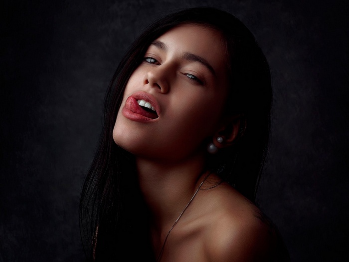 Woman with dark hair sticking out her tongue