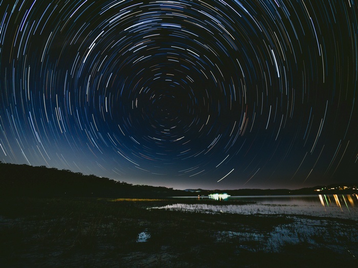Star trails over a lake at night