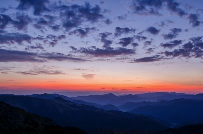Sunset over misty mountains with clouds