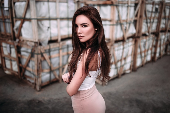 Woman with arms crossed in pink skirt outdoors