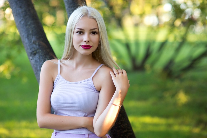 Woman with blonde hair and pink top outdoors