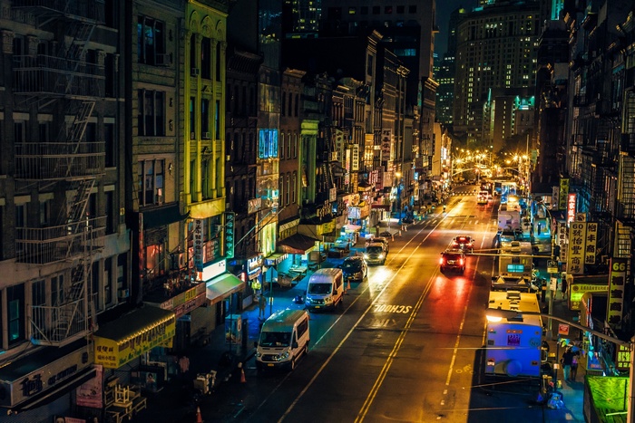 Nighttime street scene in Manhattan with traffic and illuminated buildings