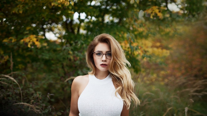 Woman with blonde hair and glasses outdoors