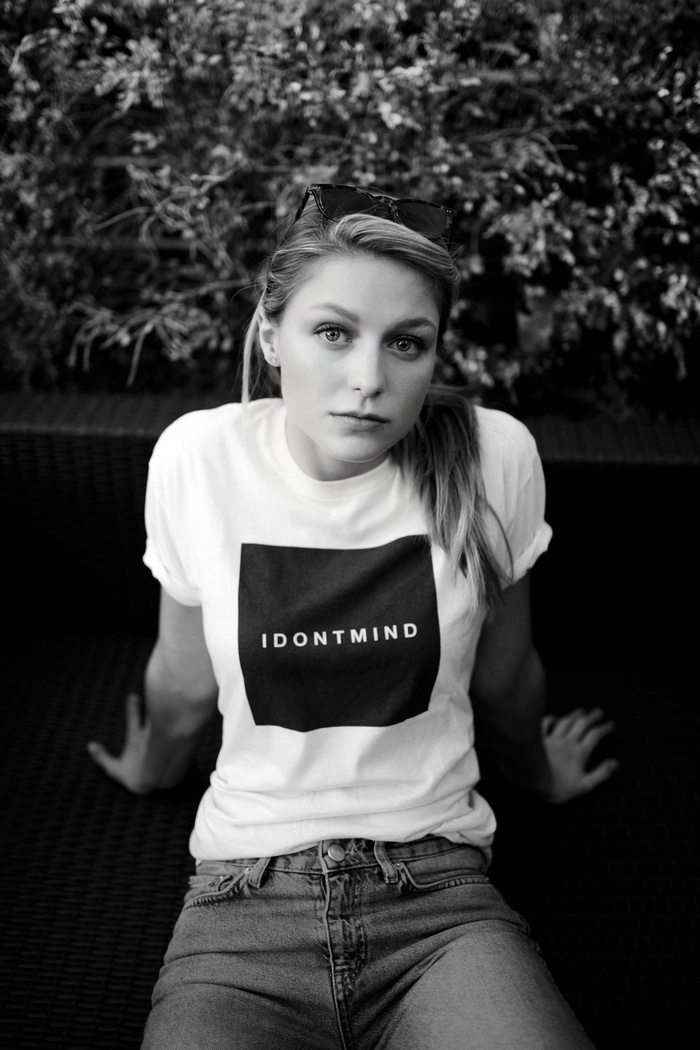 Melissa Benoist sitting outdoors wearing a t-shirt