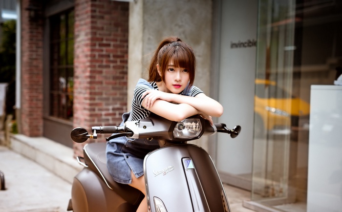 Young Asian woman on a Vespa scooter