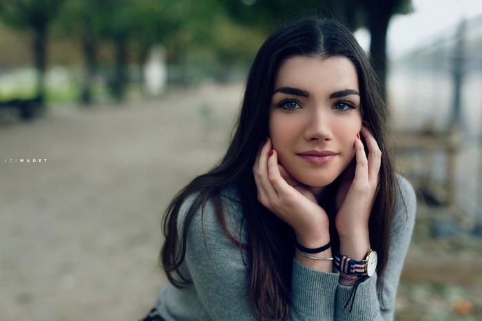 Woman with blue eyes and red nails outdoors