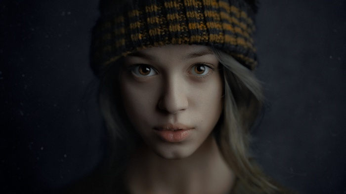 Portrait of a young girl with brown eyes wearing a beanie