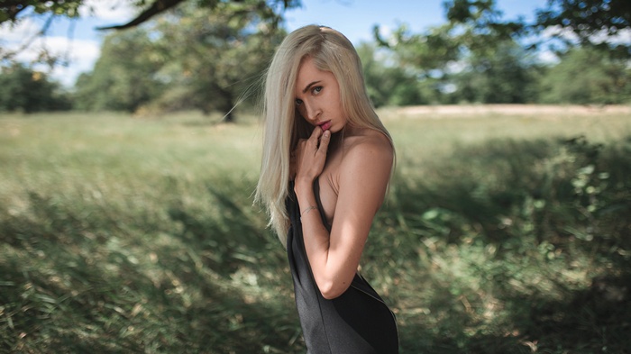 Woman with blonde hair in a black dress outdoors