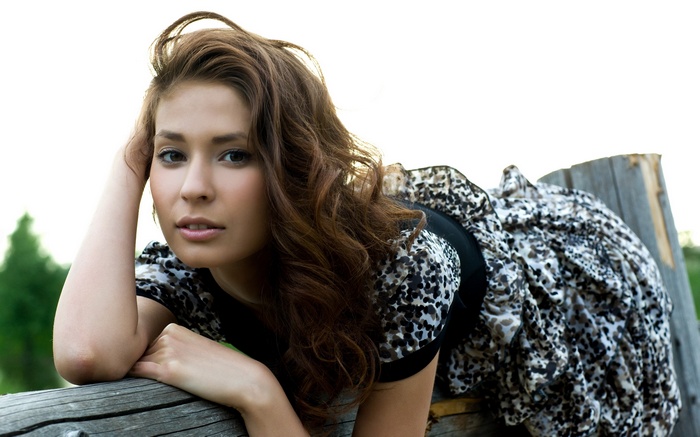 Irina J poses on a wooden fence