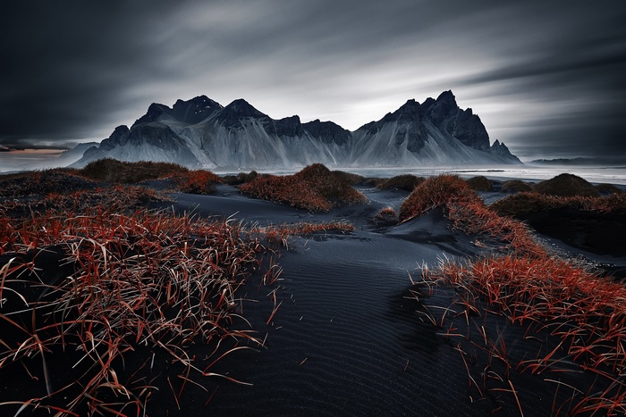 Dark landscape with mountains and black sand beach in Iceland