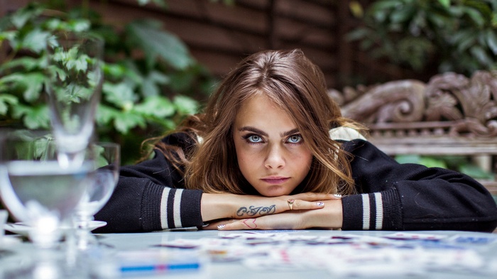 Cara Delevingne resting her head on her arms