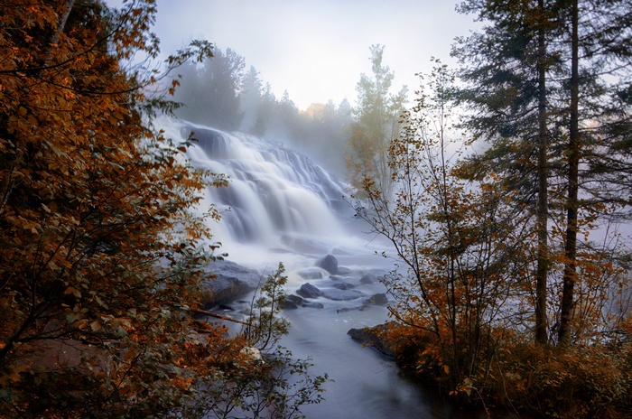 Waterfall in autumn with trees and mist