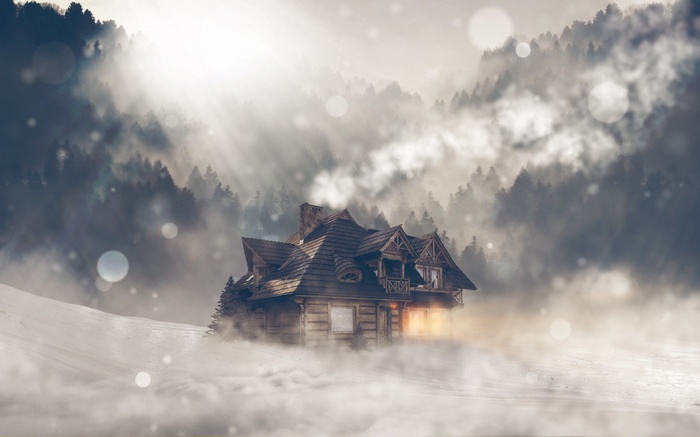 Wooden cabin in a misty winter forest with sun rays