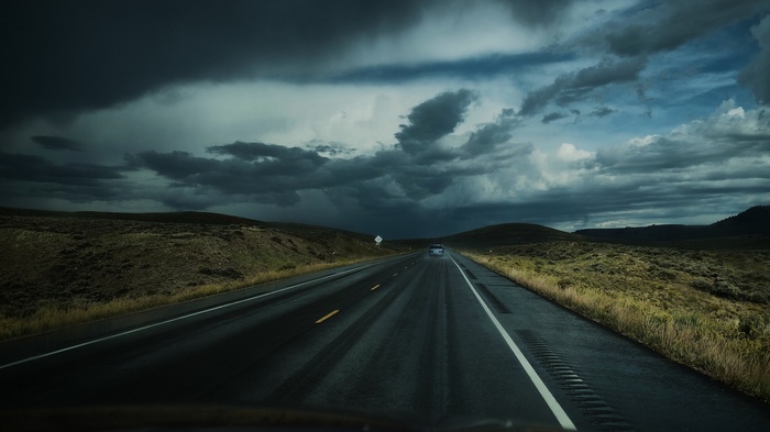 Stormy clouds over a highway in a rural landscape