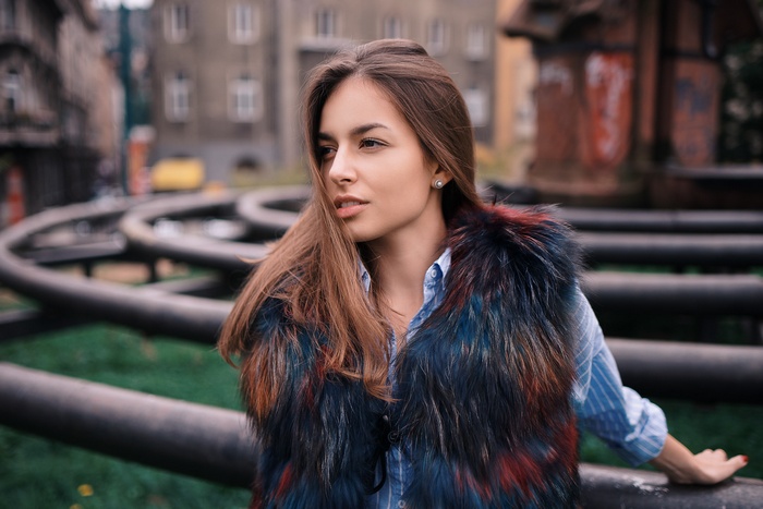 Woman wearing a fur vest and blue shirt outdoors