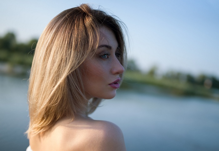 Woman with blonde hair looking away outdoors