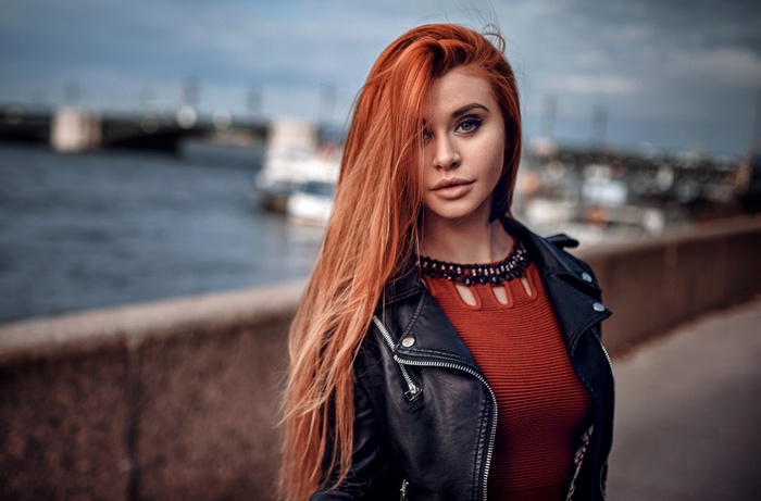 Woman with long red hair wearing a leather jacket