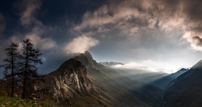 Dramatic mountain landscape with sunbeams and clouds