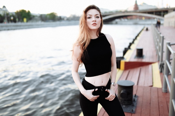 Woman in black crop top and pants on a pier
