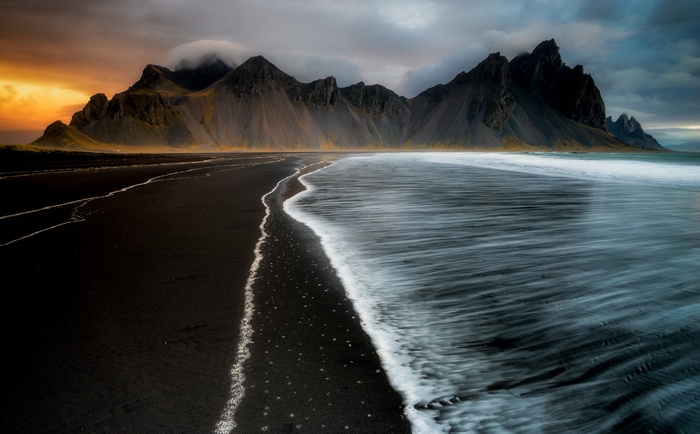 Black sand beach with mountains and ocean waves