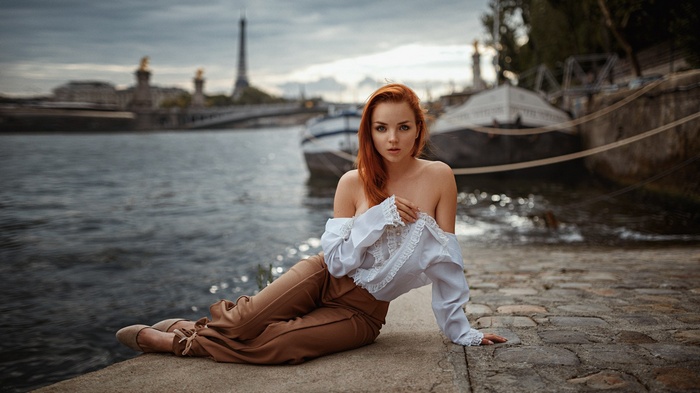 Woman posing by the Seine River in Paris