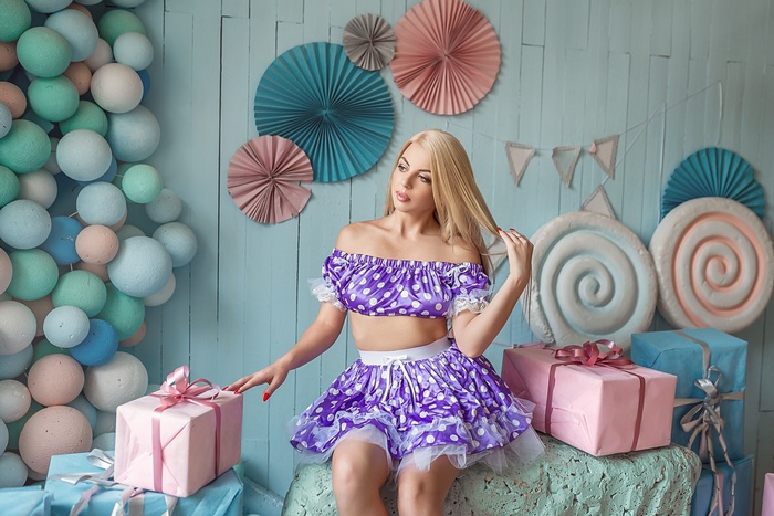 Woman in polka dot outfit sitting near gifts