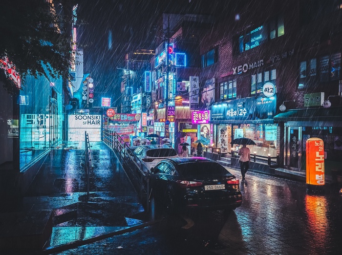 Rainy night in South Korea with neon signs and cars