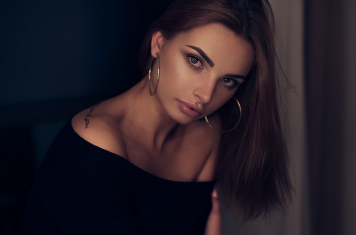 Woman with tattoo and hoop earrings