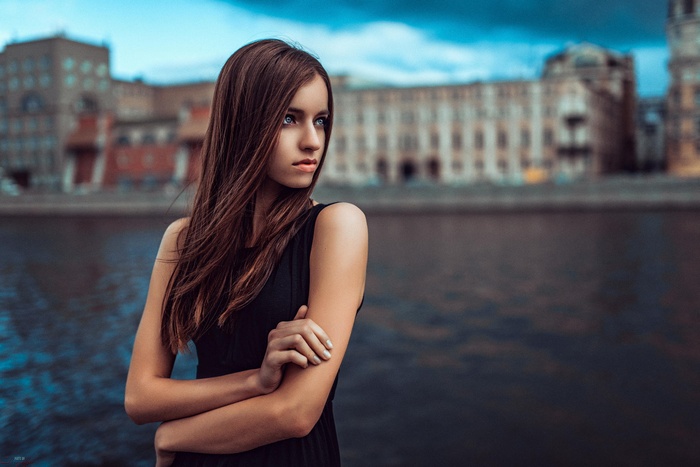 Woman in black dress by the water